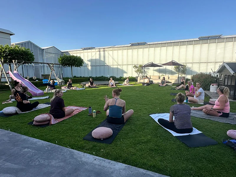 Zwangere deelnemers tijdens een yogales in de tuin